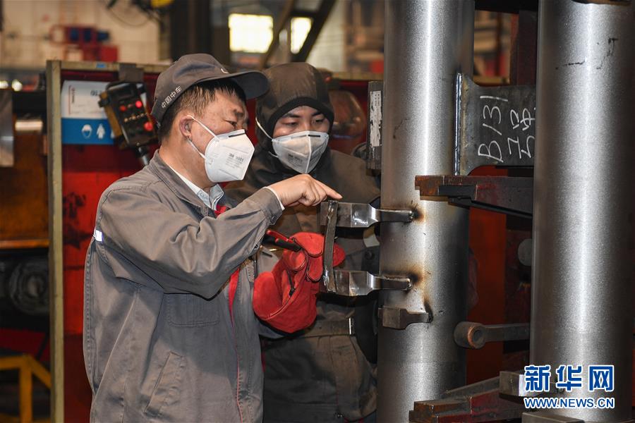 中车长春轨道客车股份有限公司高级技师李万君（左）在指导工人焊接作业中的注意事项（4月26日摄）。新华社记者 许畅 摄