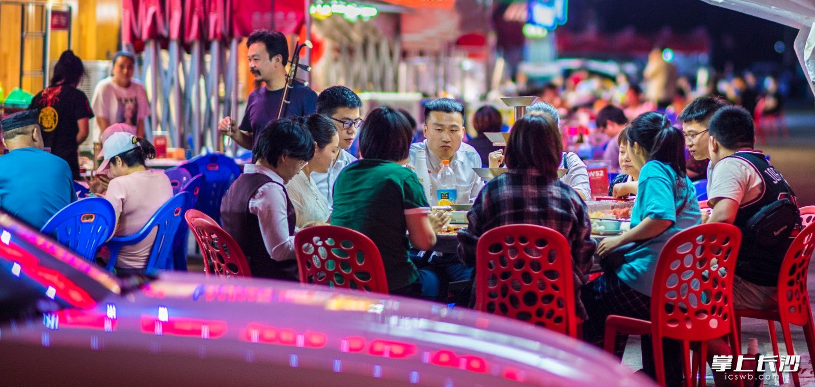 开福区湘江北路盛世路口，市民们坐在路边吃宵夜。