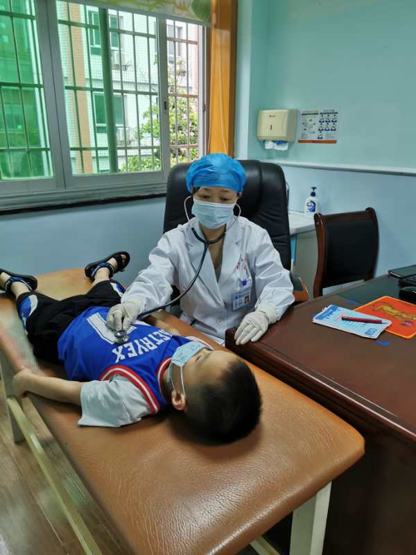 湖南省儿童医院儿童保健所所长钟燕教授给前来就诊的孩子进行检查。