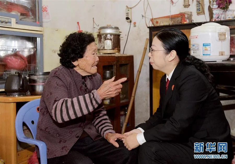 黄志丽（右）来到福建漳州市芗城区古塘村，看望她多年照顾的独居老人（2016年3月17日摄）