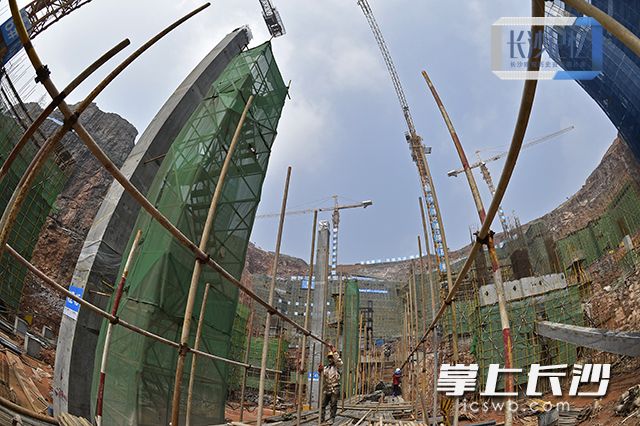 2016年3月18日，湘江欢乐城百米矿坑施工现场，施工人员在紧张进行墩柱和边坡加固施工。