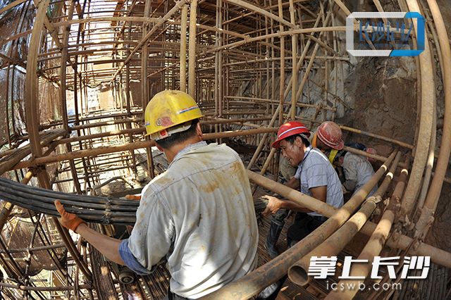 2016年6月17日，工人们穿梭在峭壁上的脚手架间进行坑壁锚索加固施工。