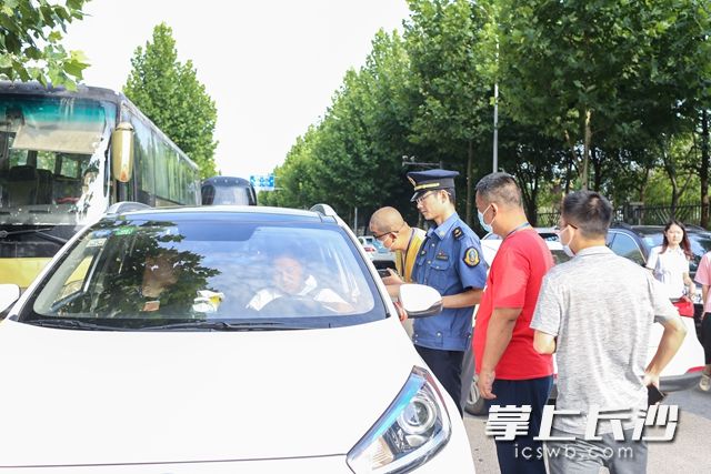 在金南家园小区北门，执法人员对涉嫌非法营运车辆进行相关证件检查。柯鸣 摄