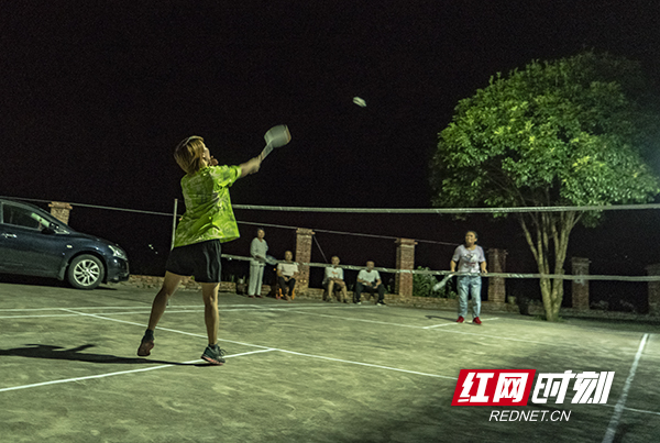 湖南岳阳平江县，灯光下，喜欢打羽毛球的村里妇女，在家附近的简易球场上，摆开了战局。