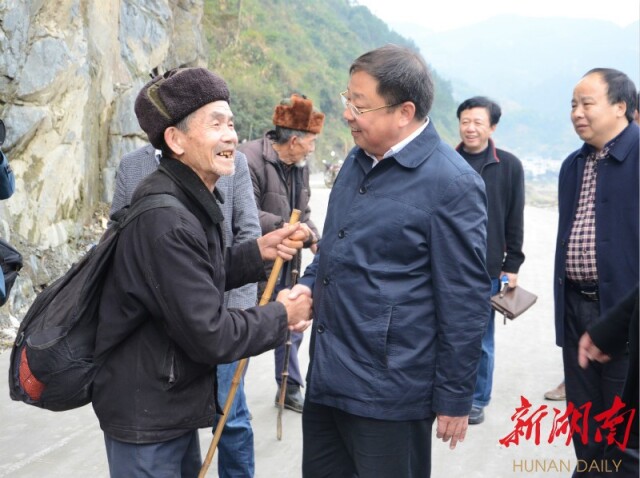 2014年12月5日，蒙汉（左二）在下乡调研途中听取群众意见建议。