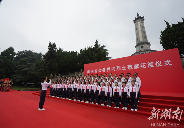 少先队员们在烈士纪念塔下唱响《我们是共产主义接班人》，向烈士致敬。