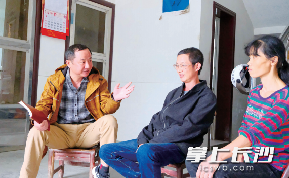 长沙晚报社驻天华村扶贫工作队队长王建刚（左）在彭德林家走访，了解近期家庭情况。章帝 摄