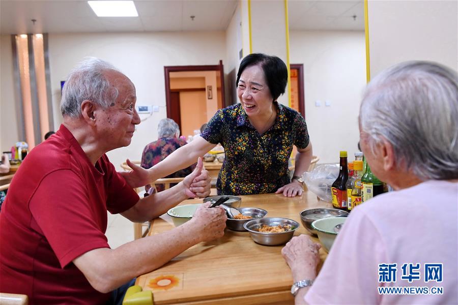 福州市鼓楼区东街街道军门社区老人刘建国（左）在社区居家养老服务照料中心就餐（2019年7月30日摄）。新华社记者 林善传 摄