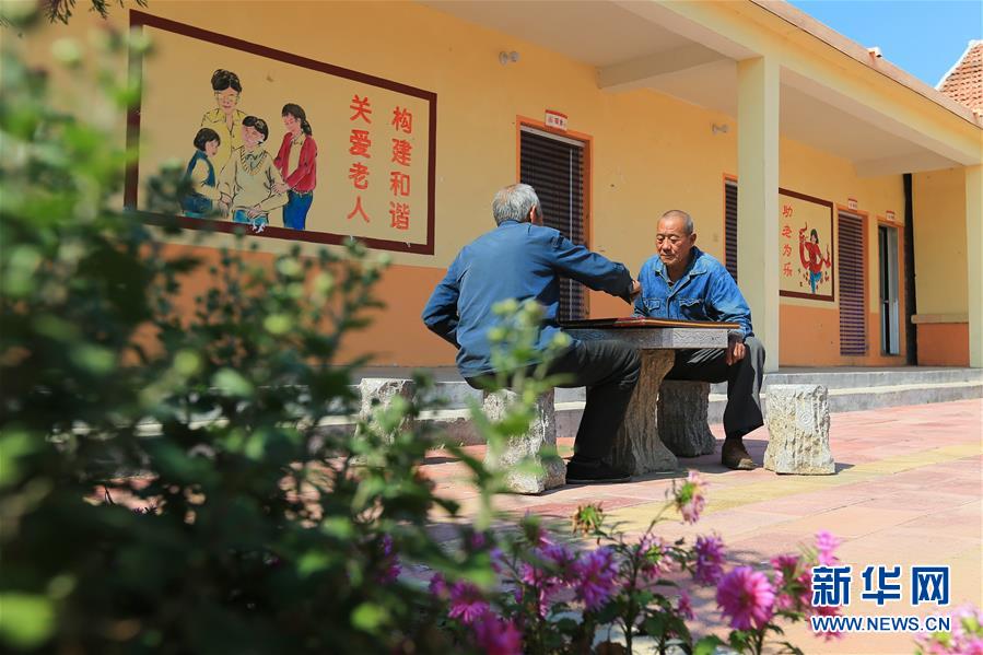在山东蒙阴县云梦湖生态区东汶社区的农村幸福院养老院，两位老人在院子里下棋（2018年10月11日摄）。新华社记者 王南 摄