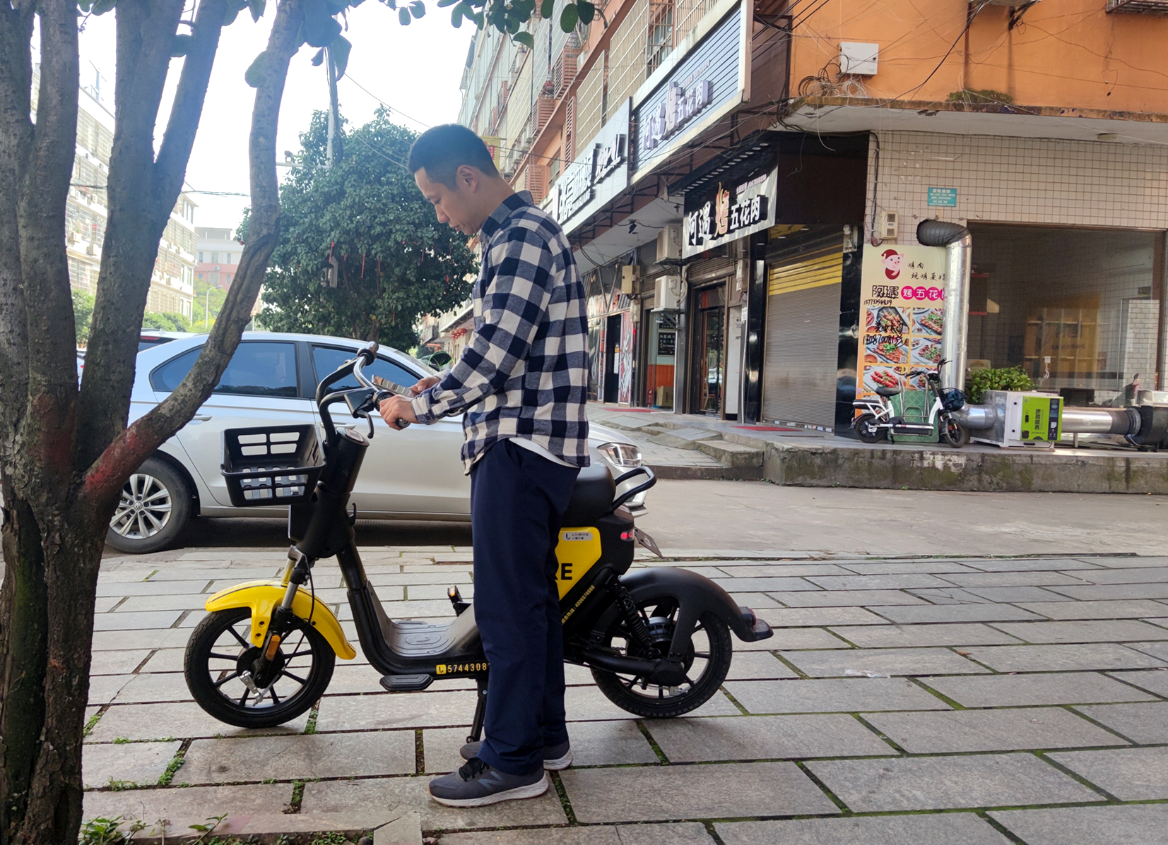 在长沙街头，陈树准备骑行共享电单车开展体验式调研。 受访者供图