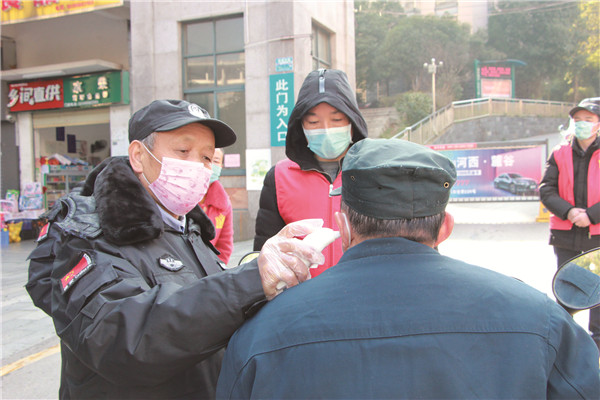 疫情期间，城郊街道山水华庭小区门口，志愿者正在对来访人员进行体温检测。