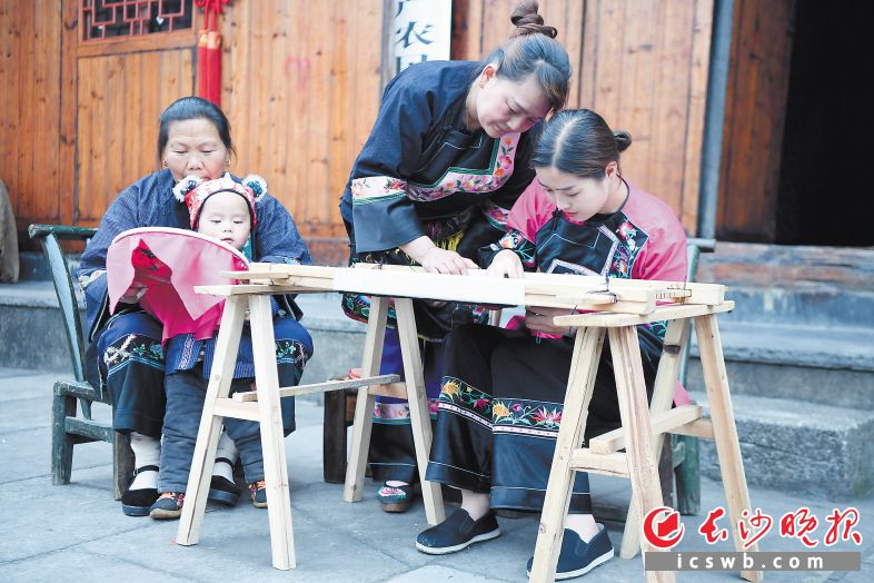 　　施林娇（右一）在十八洞村学习苗绣（2020年4月25日摄）。    新华社记者 薛宇舸 摄