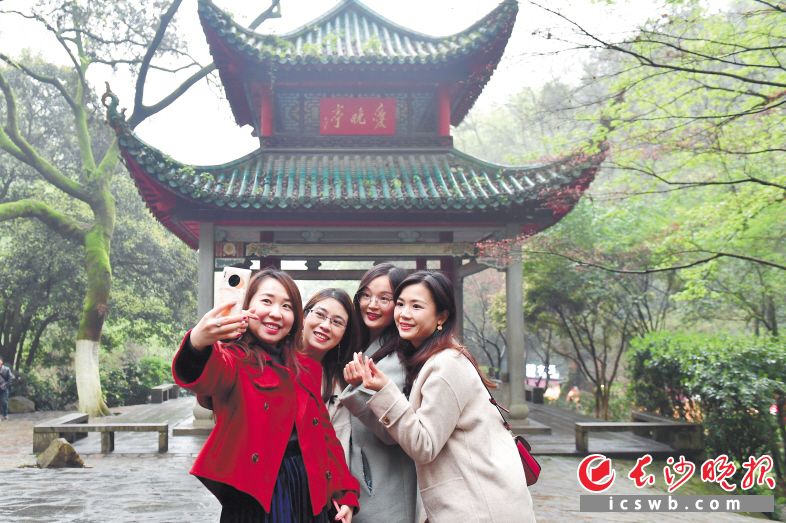 　3月20日下午，岳麓山爱晚亭前，来自广东江门的年轻游客在拍照“打卡”。长沙晚报全媒体记者 王志伟 摄