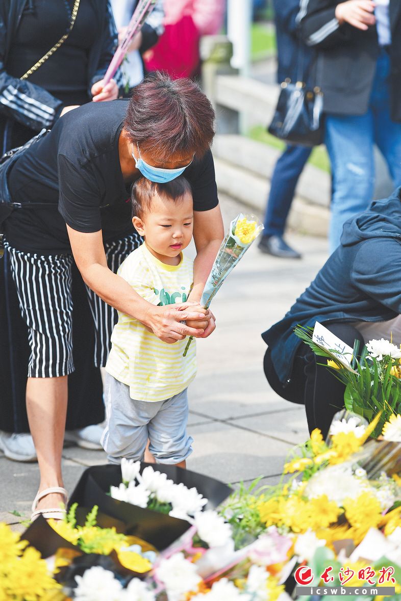 　　在长辈的陪伴下，孩子给敬爱的袁爷爷送上一枝菊花。　　长沙晚报全媒体记者 王志伟 摄