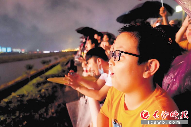 潇湘中路沿江风光带焰火观景点，小朋友看到焰火表演露出惊奇的表情。