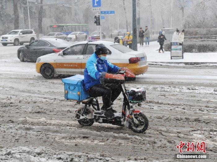 资料图：外卖小哥冒雪送餐。中新社记者 刘栋 摄