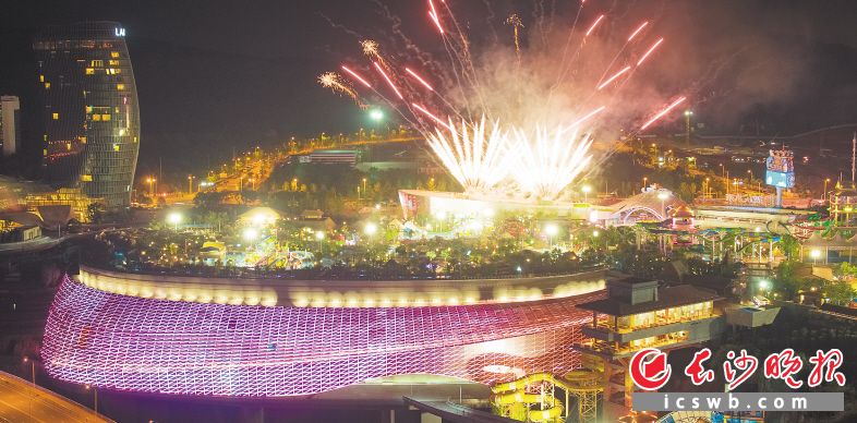 夜晚的湘江欢乐城欢乐水寨，焰火点亮天空，游客们一边戏水一边观赏烟花。长沙晚报全媒体记者 邹麟 摄