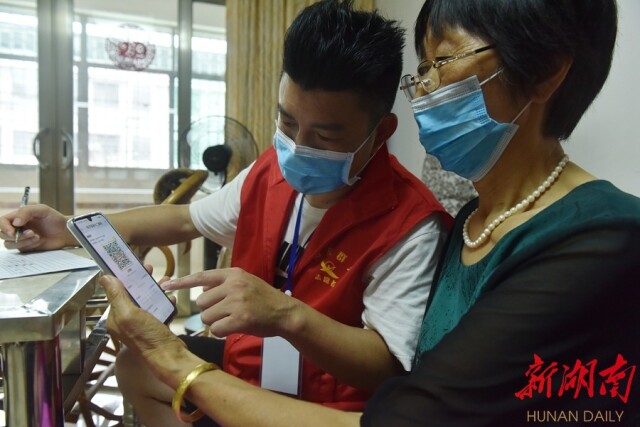 8月9日，衡东县洣水镇新世纪市场，新冠疫苗接种宣传分队上门核查居民健康码、行程码和疫苗接种情况。肖亚辉 周健 摄