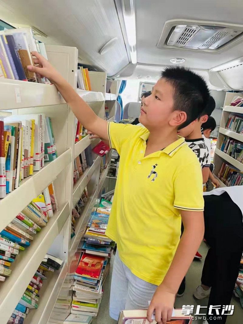 孩子们在流动“图书馆”里挑选自己喜爱的书籍。  均为长沙晚报通讯员张黎敏摄