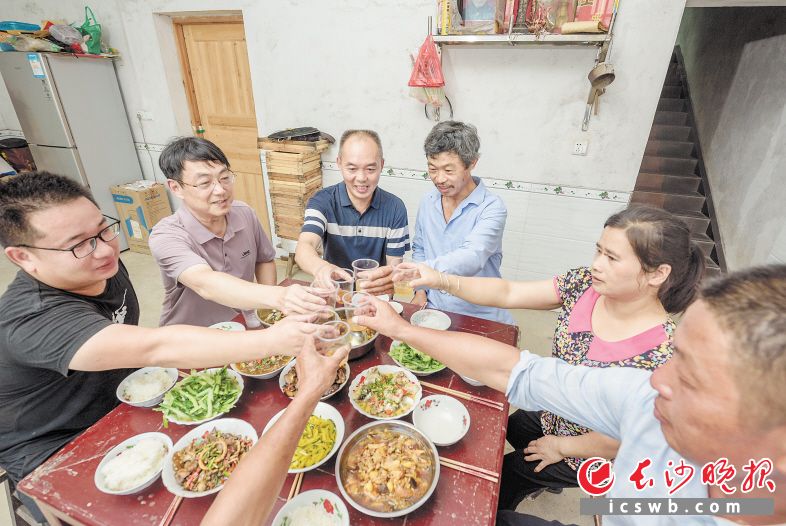 张冬高（左四）备好家宴，盛情邀请驻村第一书记和村干部、村民组长等分享丰收的快乐。