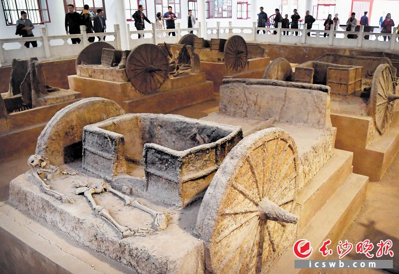 　　游客在河南安阳殷墟宫殿宗庙遗址内的车马坑参观。