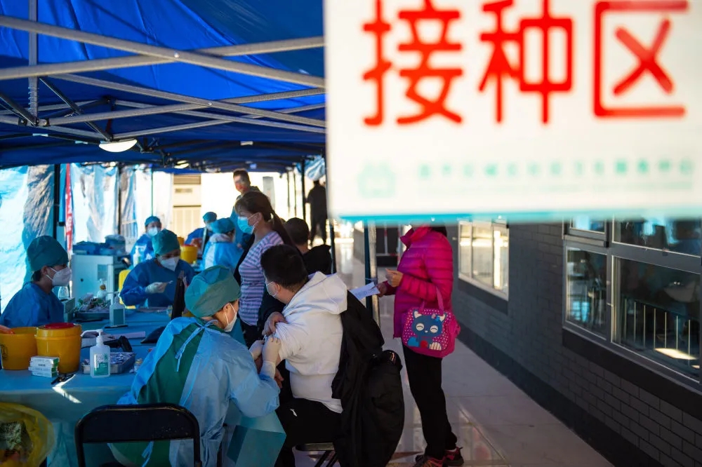 10月23日，在北京市昌平区城南街道化庄棚改大厅临时接种点，医护人员为市民接种加强针。新华社记者 陈钟昊 摄