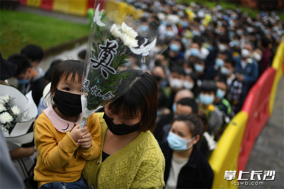 5月23日，一位女孩被父母抱着进入殡仪馆缅怀袁老。