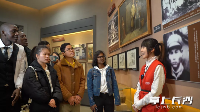 湖南师范大学外国语学院学生志愿者讲解员向外国留学生讲述雷锋故事。    均为学校供图