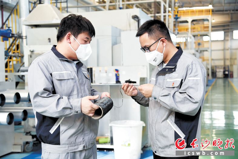 　　东映碳材的青年党员在生产线上检测产品。李昊哲 摄