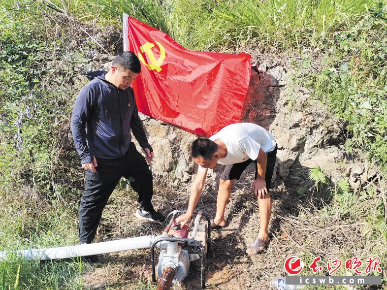 　　为了保证抗旱用水，宁乡市横市镇合金村党员干部仔细检查抽水设备。                                 王亚婷  摄
