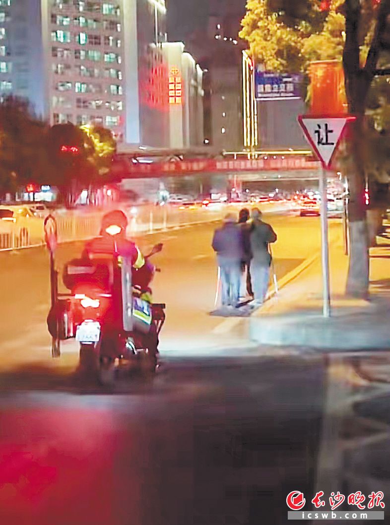 　　3位老年盲人走在马路上，特警铁骑队员在其身后慢慢骑行护送。　　网友“lan”的视频截图