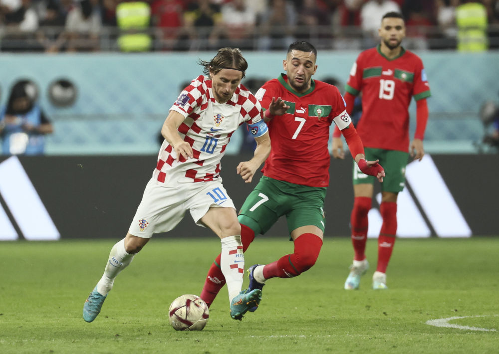 12月17日，克罗地亚队球员莫德里奇（左）在比赛中突破摩洛哥队球员齐耶赫的防守。新华社记者 兰红光 摄