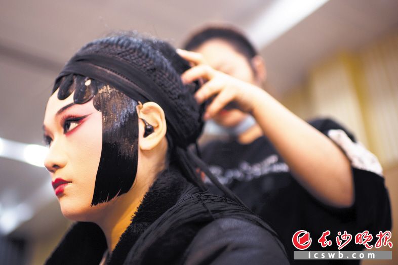 演员赵月红正在上妆贴发片。虽然是网上演出，但演员的妆容跟现场表演分毫不差。