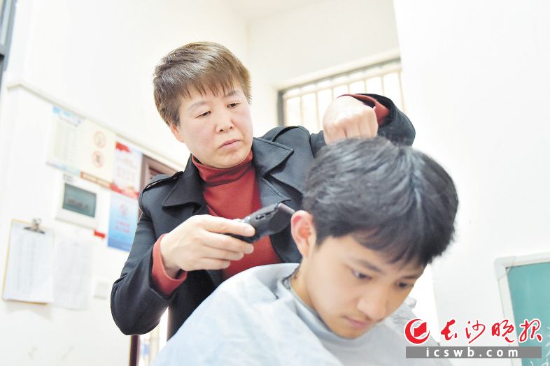 在值班室里，生活老师申玉娥为学生免费剪头发。　　长沙晚报全媒体记者 刘琦 通讯员 皮佳怡 摄影报道