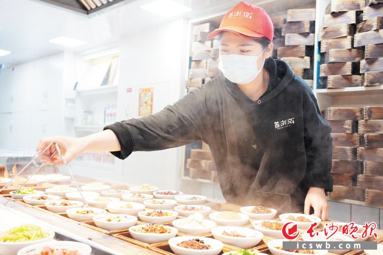 　　“蒸浏记”门店店员正在为顾客准备一荤一素的“江湖救急餐”。